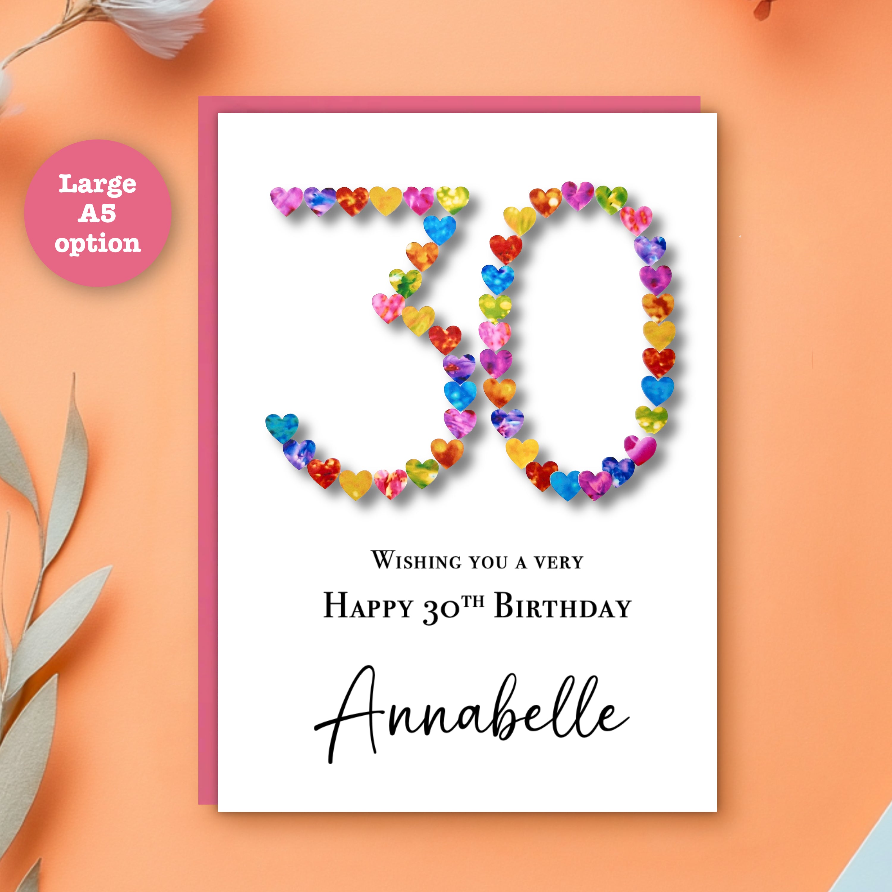A5 size Personalised 30th birthday card with colourful hearts arranged in the number 30 with a name and happy birthday printed on it, with a pink envelope on an orange background