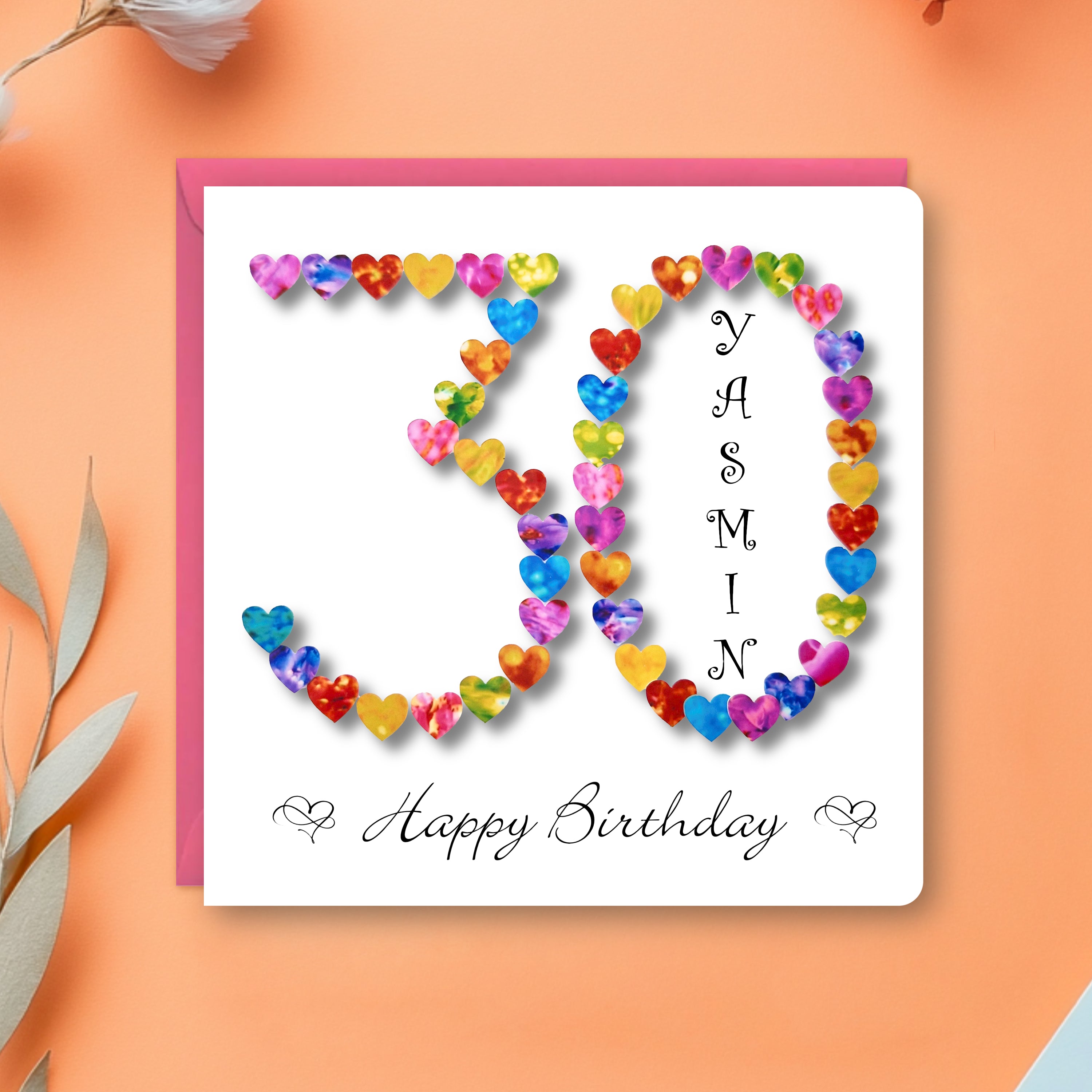 Personalised 30th birthday card with colourful hearts arranged in the number 30 with a name and happy birthday printed on it, with a pink envelope on an orange background